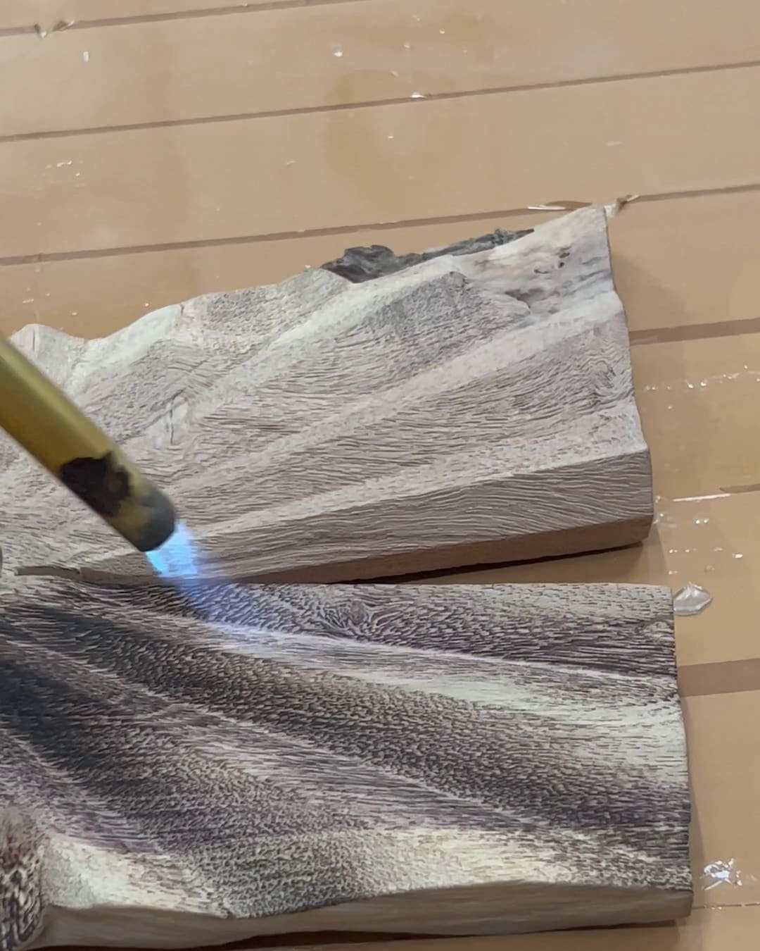 Torch-finishing a carved wood panel at the Family Hub factory